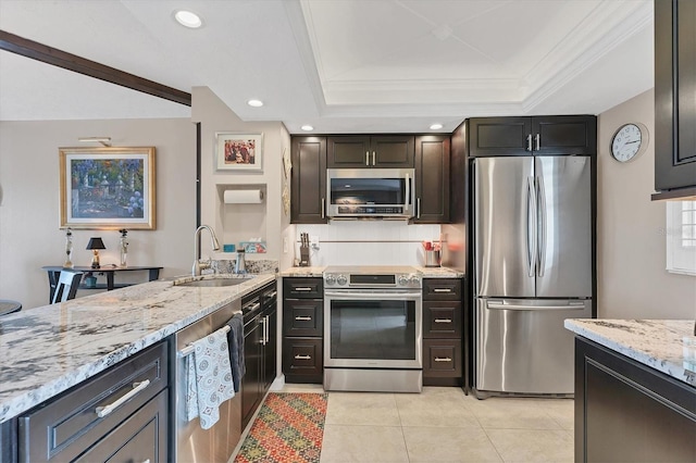 kitchen featuring light tile patterned flooring, a raised ceiling, sink, ornamental molding, and stainless steel appliances