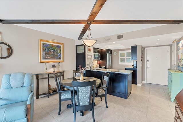 tiled dining area featuring sink and beam ceiling