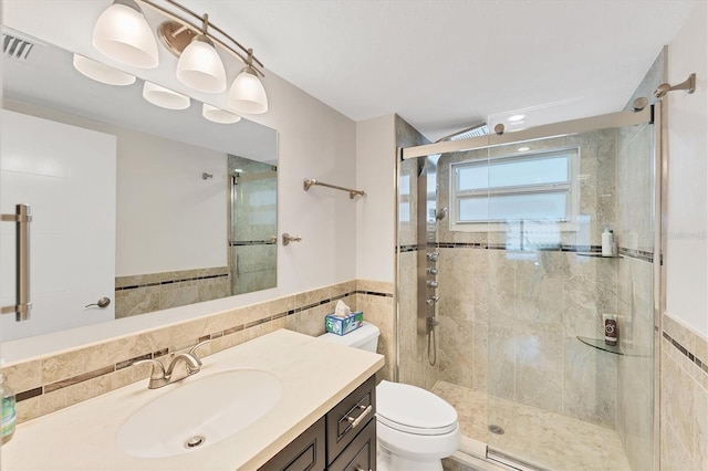 bathroom with vanity, tile walls, an enclosed shower, and toilet