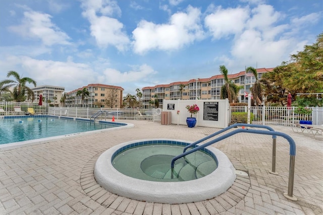 view of pool featuring a hot tub and a patio