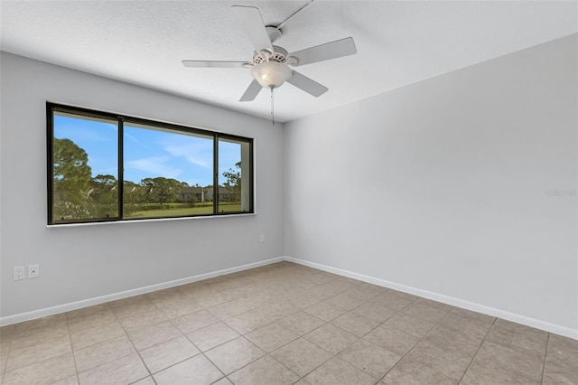 empty room with ceiling fan, a textured ceiling, and light tile patterned floors