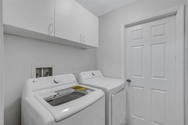 washroom featuring cabinets and separate washer and dryer