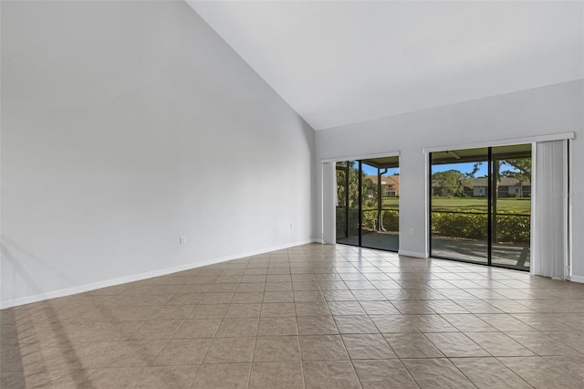 spare room with high vaulted ceiling and light tile patterned floors