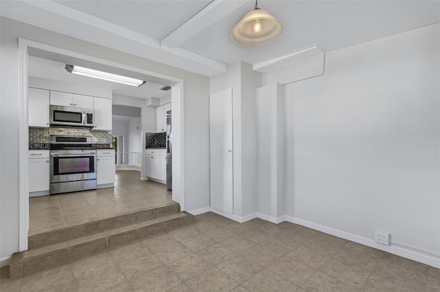 3119 Heatherwood Ln, Sarasota, FL 34235 - kitchen featuring appliances with stainless steel finishes, dark countertops, white cabinets, decorative backsplash, and light tile patterned floors