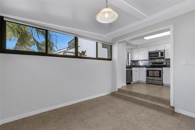 3119 Heatherwood Ln, Sarasota, FL 34235 - kitchen featuring stainless steel appliances, white cabinets, baseboards, decorative backsplash, and dark countertops