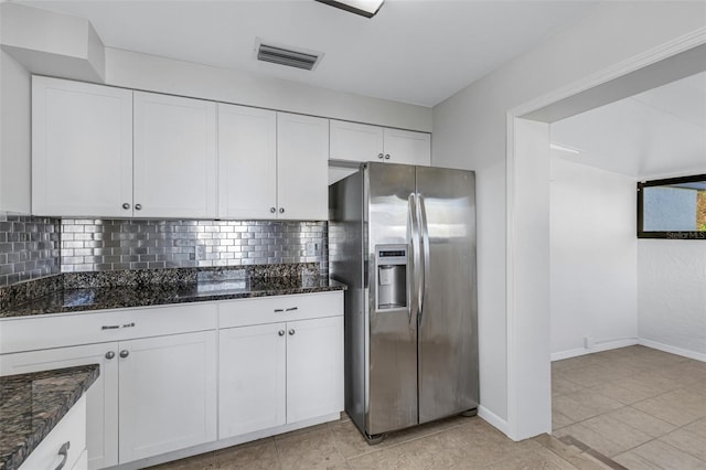 kitchen featuring white cabinets, tasteful backsplash, dark stone counters, and stainless steel fridge with ice dispenser