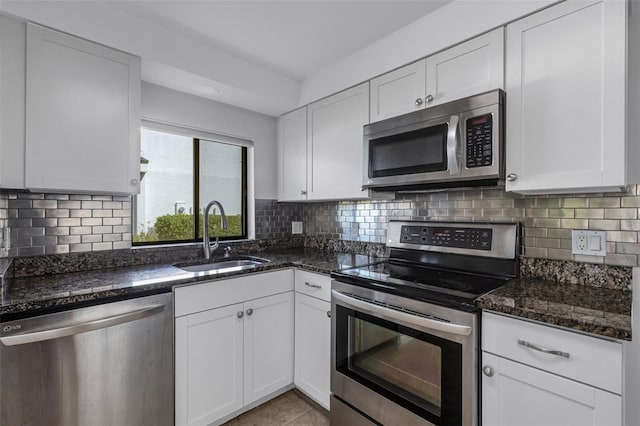 kitchen with white cabinetry, stainless steel appliances, tasteful backsplash, and sink