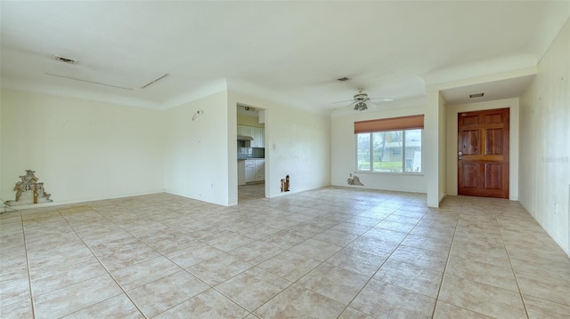 empty room with ceiling fan and light tile patterned flooring