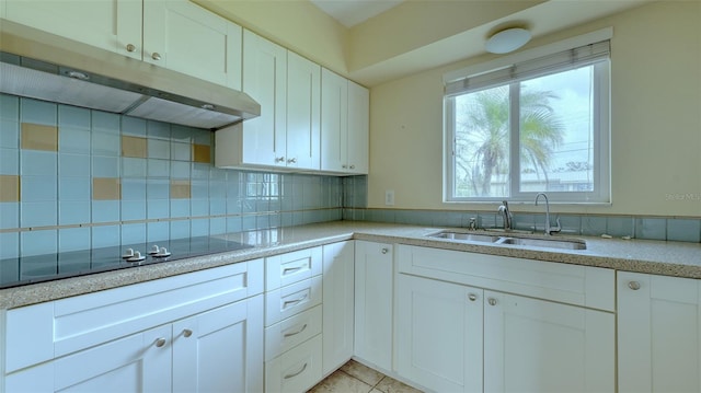 kitchen featuring white cabinetry, sink, tasteful backsplash, light tile patterned floors, and black electric stovetop