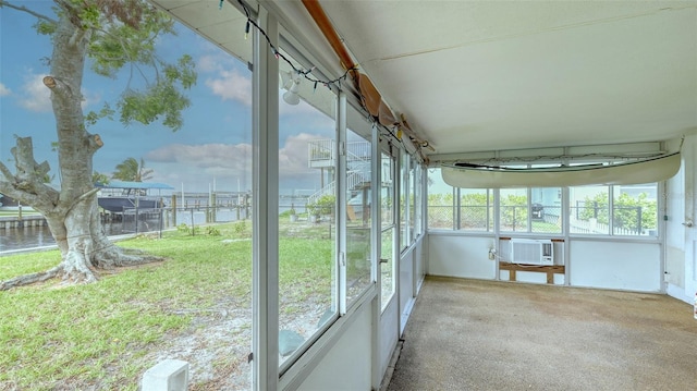 unfurnished sunroom featuring cooling unit, a water view, and a healthy amount of sunlight