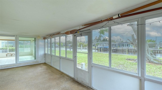 unfurnished sunroom featuring a water view