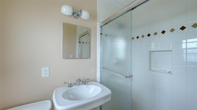 bathroom featuring sink and a shower with shower door