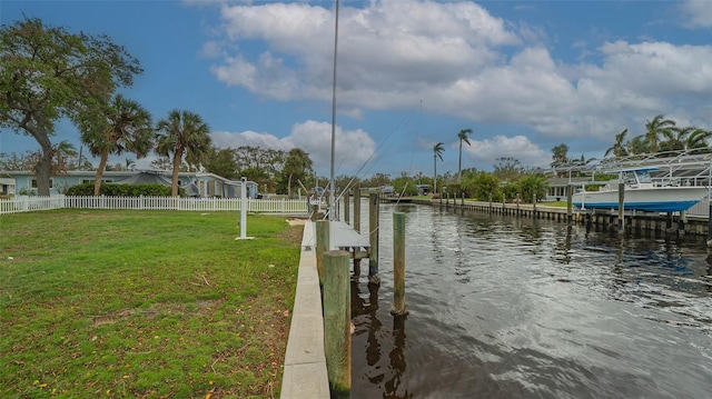 view of dock with a water view and a lawn