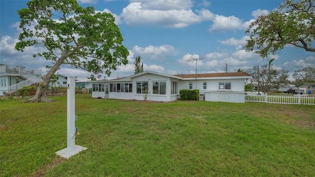 back of property featuring a lawn and a sunroom