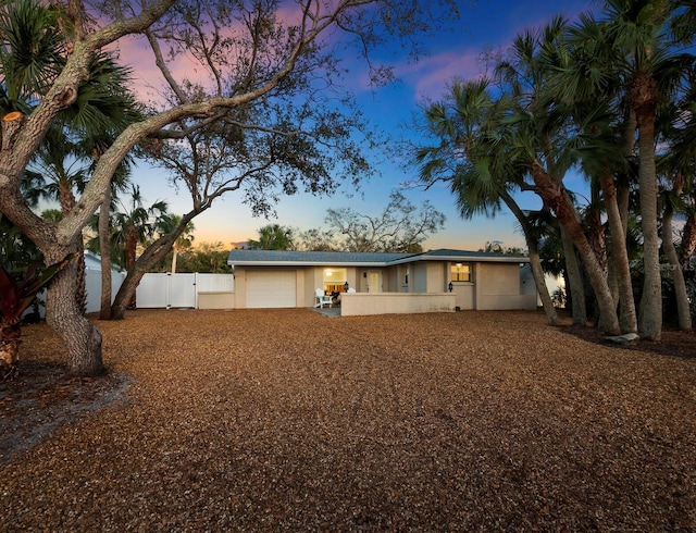 back house at dusk featuring a garage