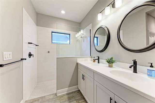 bathroom with vanity and a tile shower