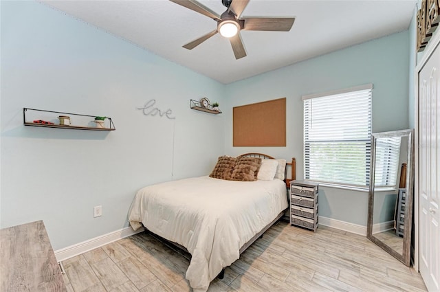 bedroom with ceiling fan, a closet, and light hardwood / wood-style flooring