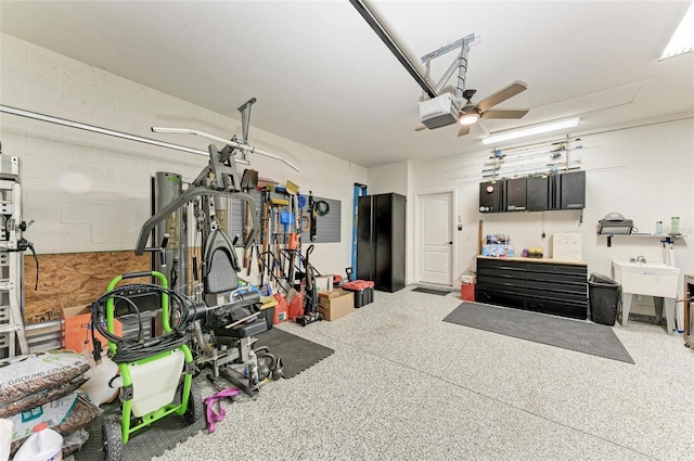 garage featuring ceiling fan, sink, and a garage door opener