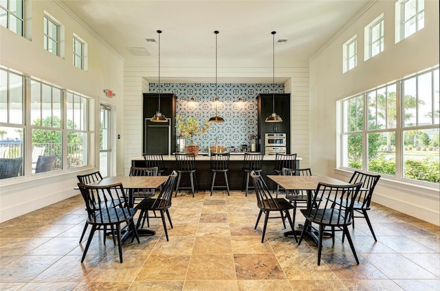 dining area with ornamental molding and a high ceiling