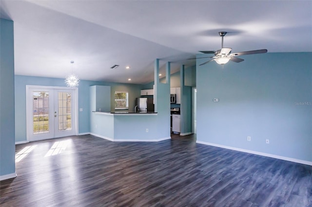 unfurnished living room featuring french doors, ceiling fan with notable chandelier, dark wood-type flooring, and lofted ceiling