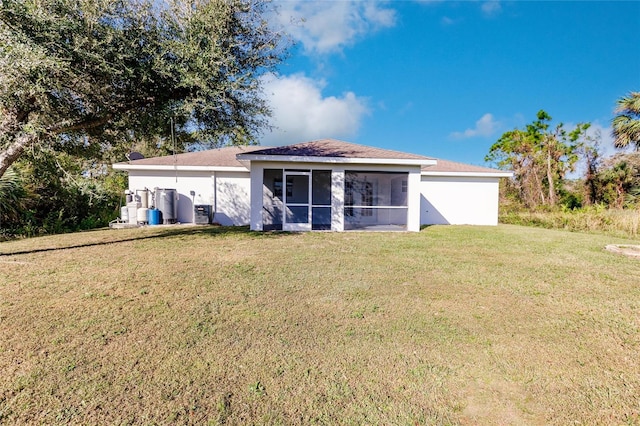 back of property with a yard and a sunroom