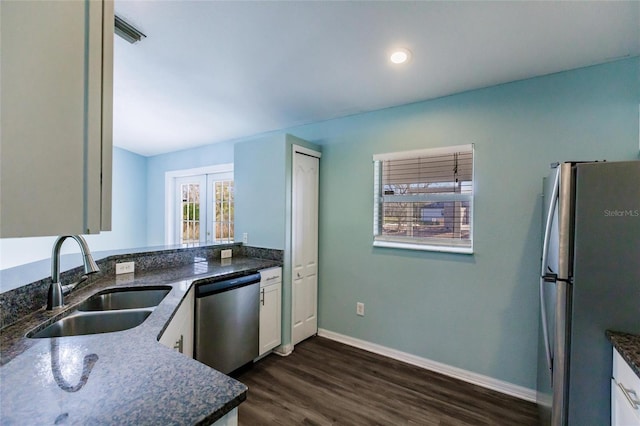 kitchen with sink, stainless steel appliances, dark stone countertops, and white cabinets