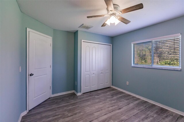 unfurnished bedroom featuring a closet, ceiling fan, and hardwood / wood-style flooring