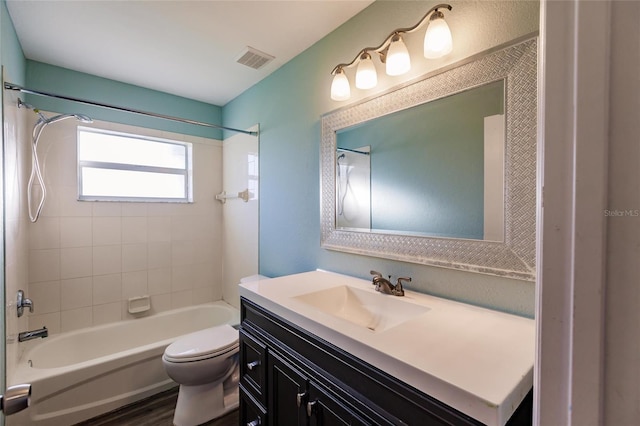 full bathroom featuring wood-type flooring, toilet, tiled shower / bath, and vanity