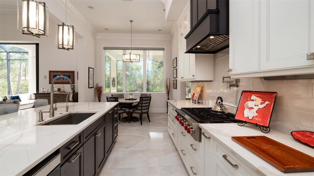 kitchen featuring decorative light fixtures, custom range hood, a healthy amount of sunlight, and white cabinets