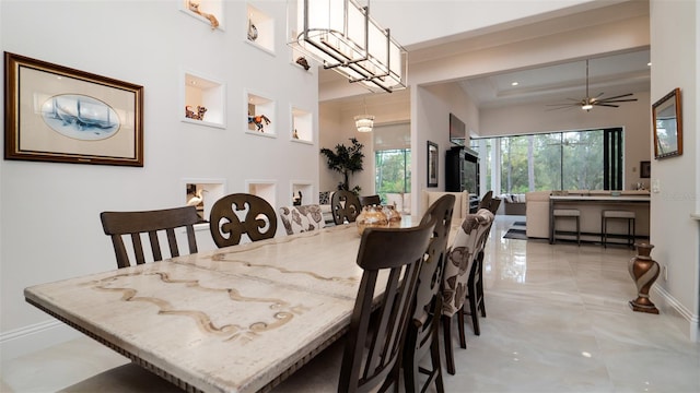 dining area with ceiling fan and ornamental molding