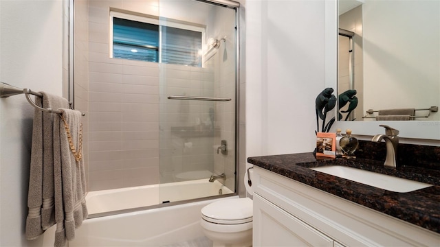 full bathroom with vanity, combined bath / shower with glass door, and toilet