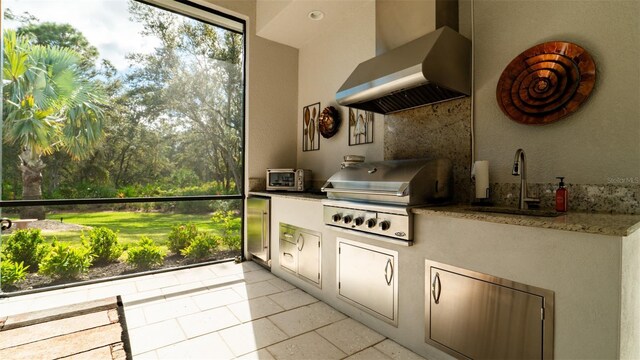 9260 Swaying Branch Rd, Sarasota, FL 34241 - kitchen featuring wall chimney range hood, a sink, built in refrigerator, light tile patterned floors, and decorative backsplash