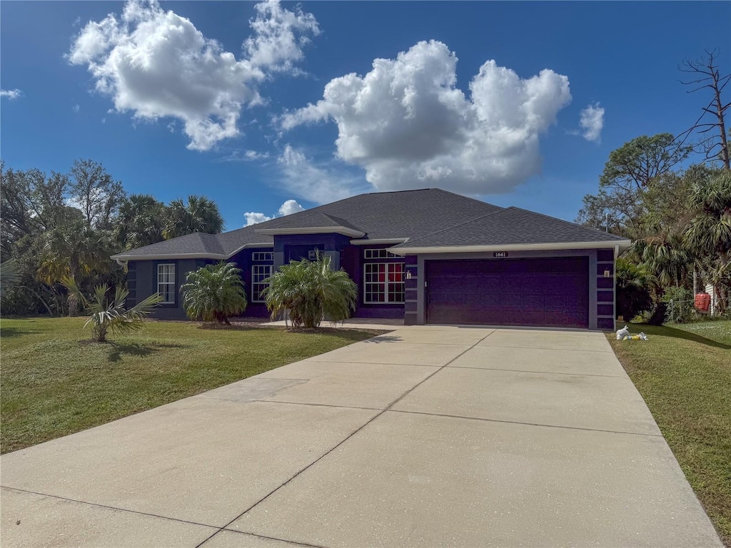 1661 Atwater Dr, North Port, FL 34288 - view of front of house featuring a garage, driveway, a front lawn, and a shingled roof