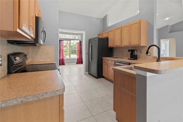 kitchen with kitchen peninsula, appliances with stainless steel finishes, light brown cabinetry, and backsplash