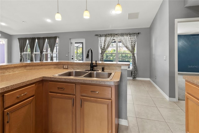 kitchen featuring hanging light fixtures, light tile patterned floors, and sink