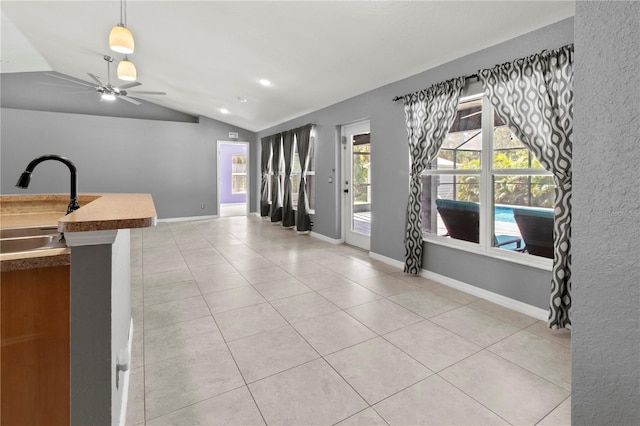 kitchen with sink, ceiling fan, light tile patterned floors, and vaulted ceiling