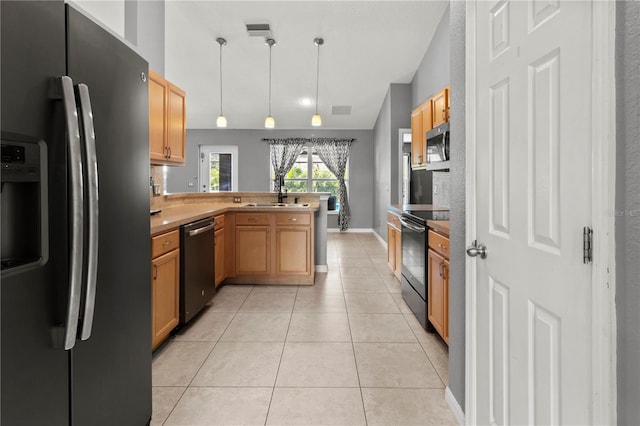 kitchen with stainless steel appliances, lofted ceiling, kitchen peninsula, hanging light fixtures, and light tile patterned floors