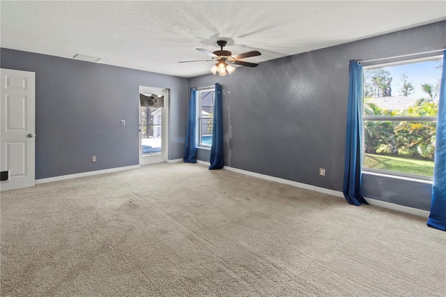 carpeted spare room featuring a healthy amount of sunlight and ceiling fan