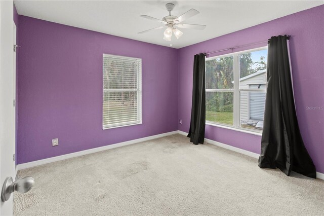 empty room featuring light colored carpet and ceiling fan