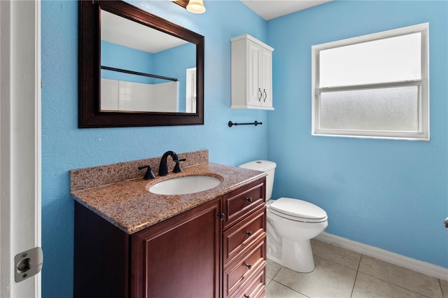 bathroom with toilet, vanity, tile patterned floors, and a shower