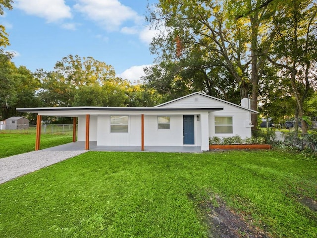 single story home featuring a front lawn and a carport