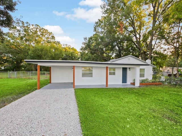 ranch-style home featuring a front lawn and a carport