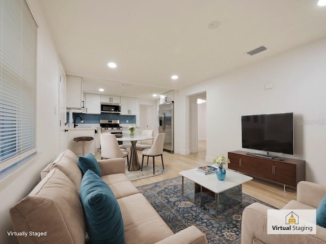 living room featuring sink and light wood-type flooring