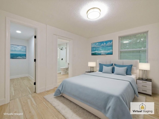 bedroom featuring ensuite bath, a textured ceiling, and light wood-type flooring