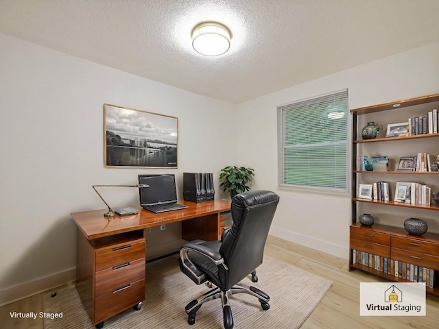 office with a textured ceiling and light wood-type flooring