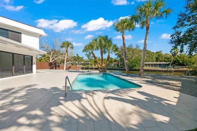 view of pool featuring a water view and a patio area