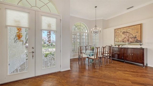 dining room featuring hardwood / wood-style flooring, a chandelier, crown molding, and french doors