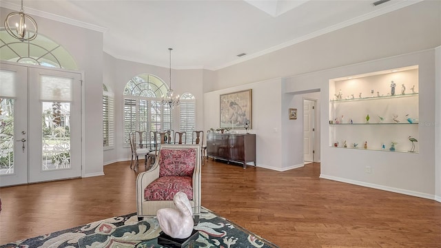 sitting room featuring french doors, a notable chandelier, a healthy amount of sunlight, and dark hardwood / wood-style floors