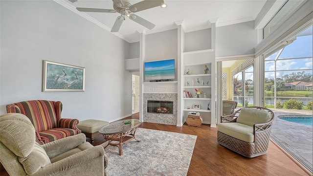 living room featuring ornamental molding, ceiling fan, dark hardwood / wood-style floors, and a towering ceiling