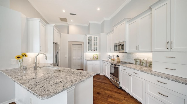 kitchen with stainless steel appliances, sink, light stone countertops, white cabinets, and dark hardwood / wood-style flooring